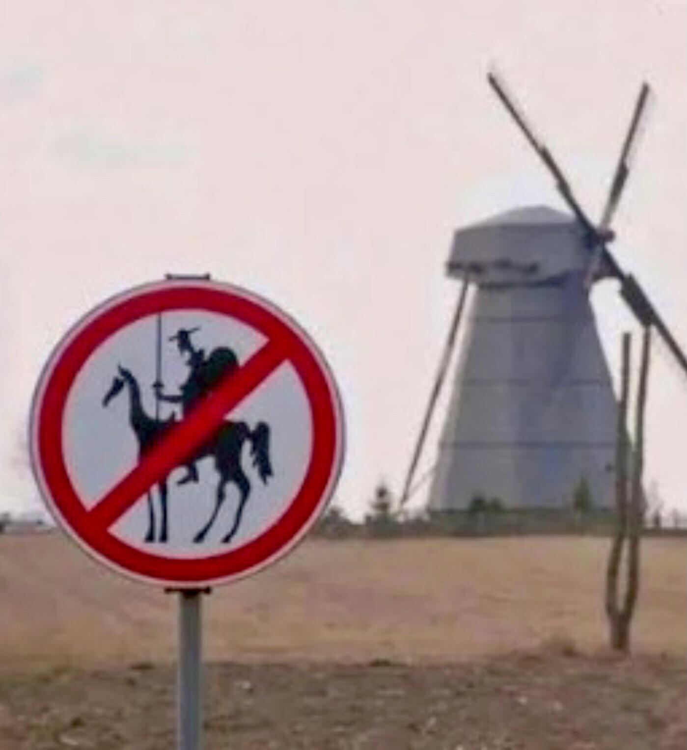 r/funny - a sign warns motorists to beware of the windmills.
