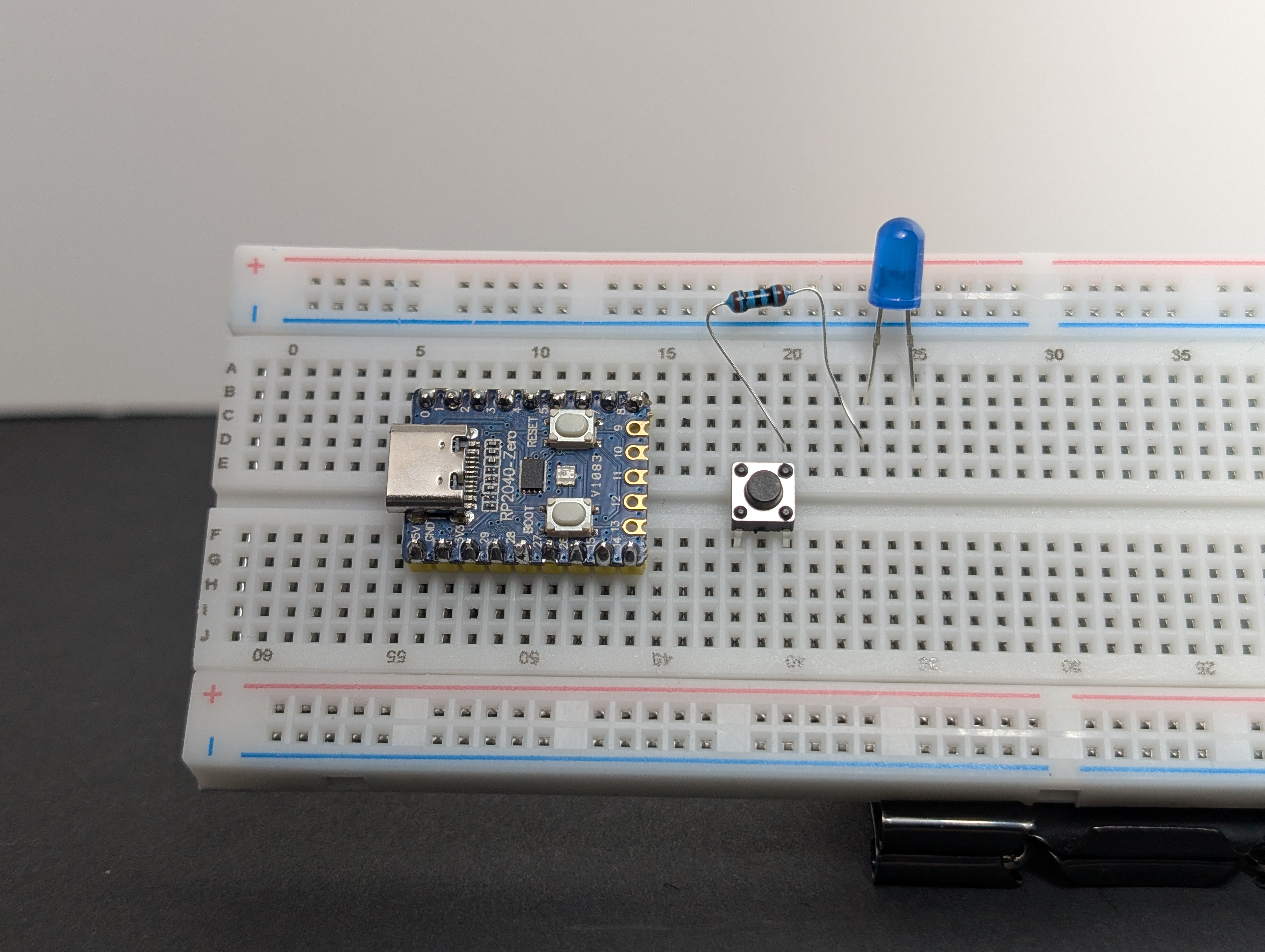 Put the resistor between one side of the button and the long leg (+) of the LED (in series).
