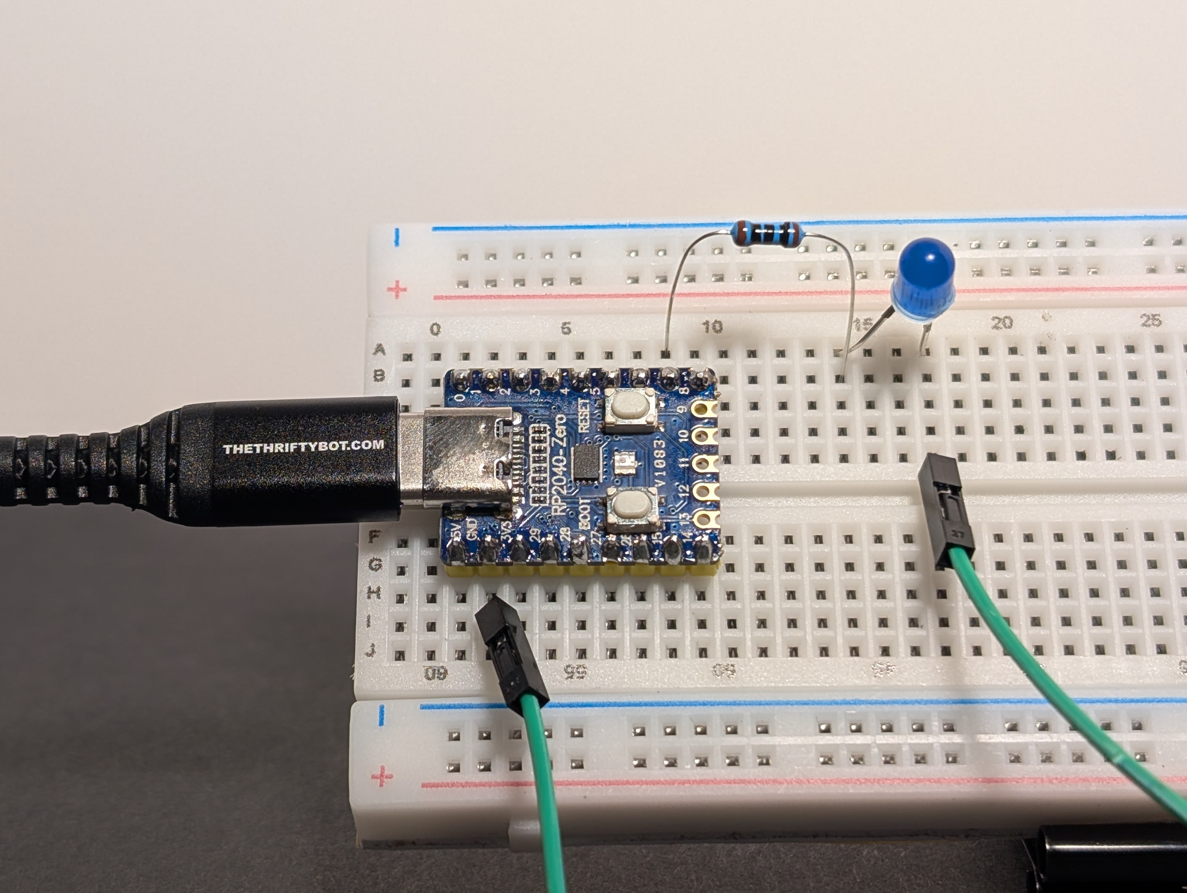 Wiring diagram showing GP7 (GPIO 7) connected through a resistor to an LED, with the LED returning to GND