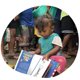 A Photo of a Child Holding a Book with a Loose Grip