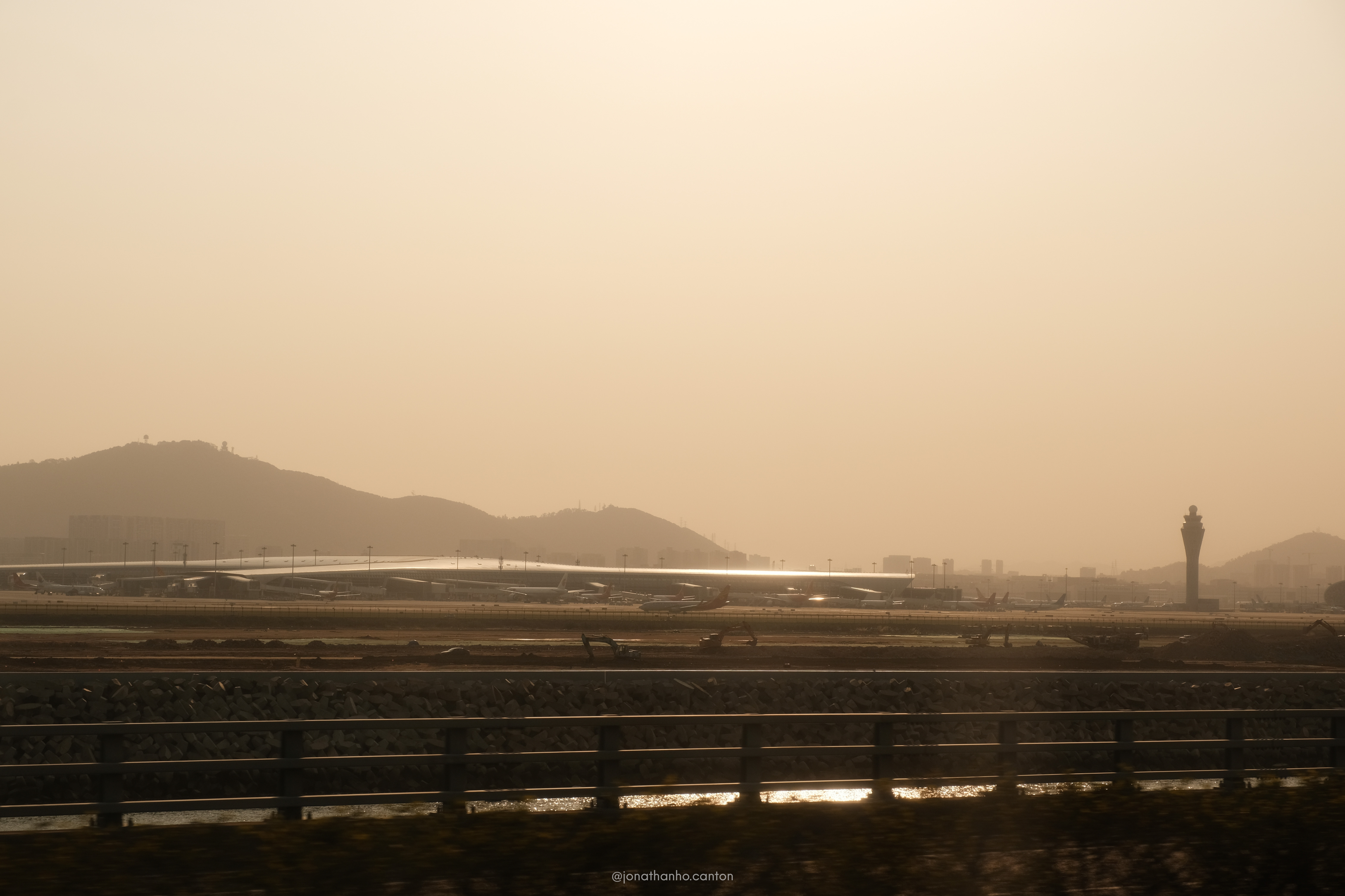 搭大巴經過深圳機場外圍，日出的曙光照着機場
