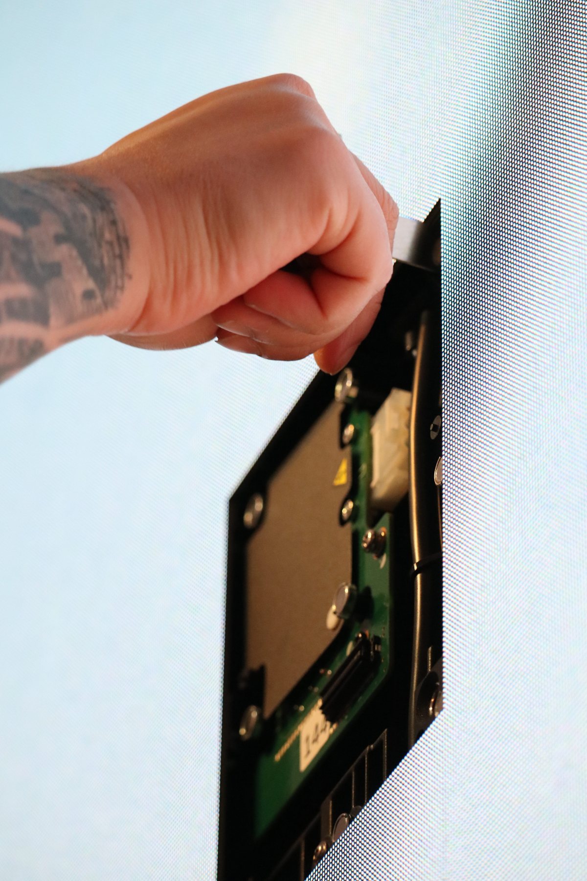 A technician pulling an LED module from the wall