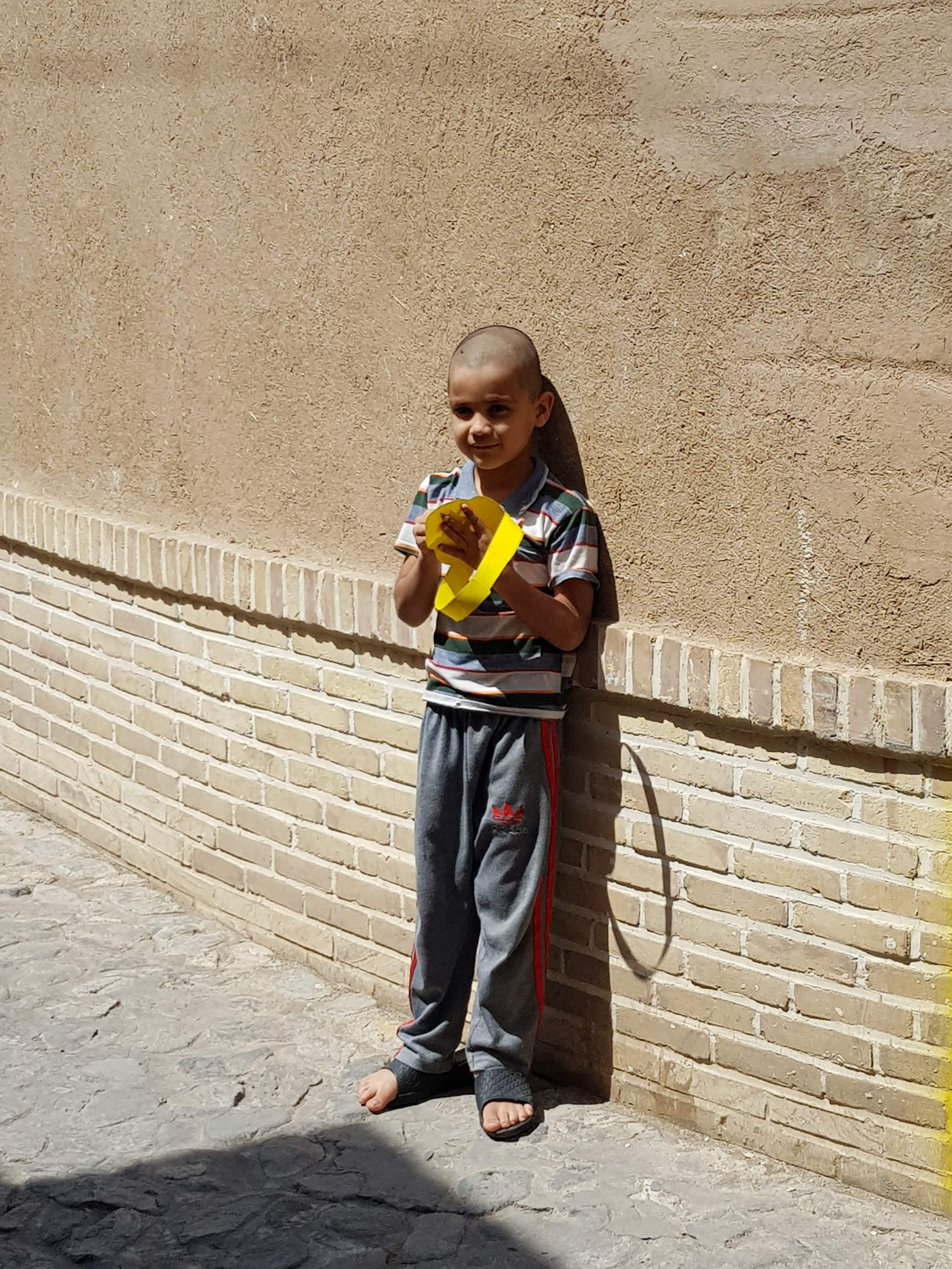 A boy in Kashan holding a paper crown
