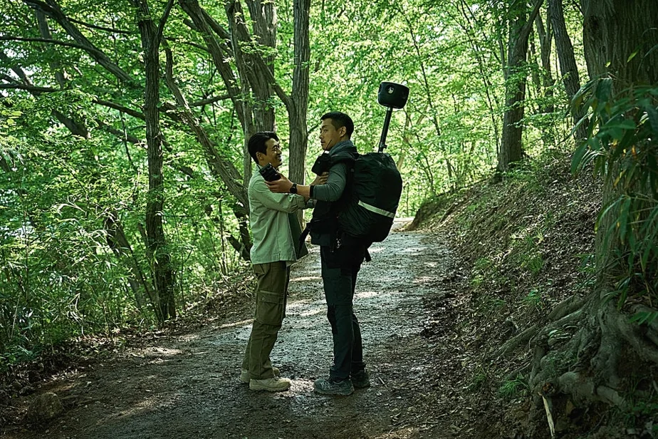 日差しの差し込む森の小道で緊張した様子で会話する二人の男性 - 韓国を震撼させる映画『サルモクチ』の世界。忠清南道・礼山への聖地巡礼ガイド