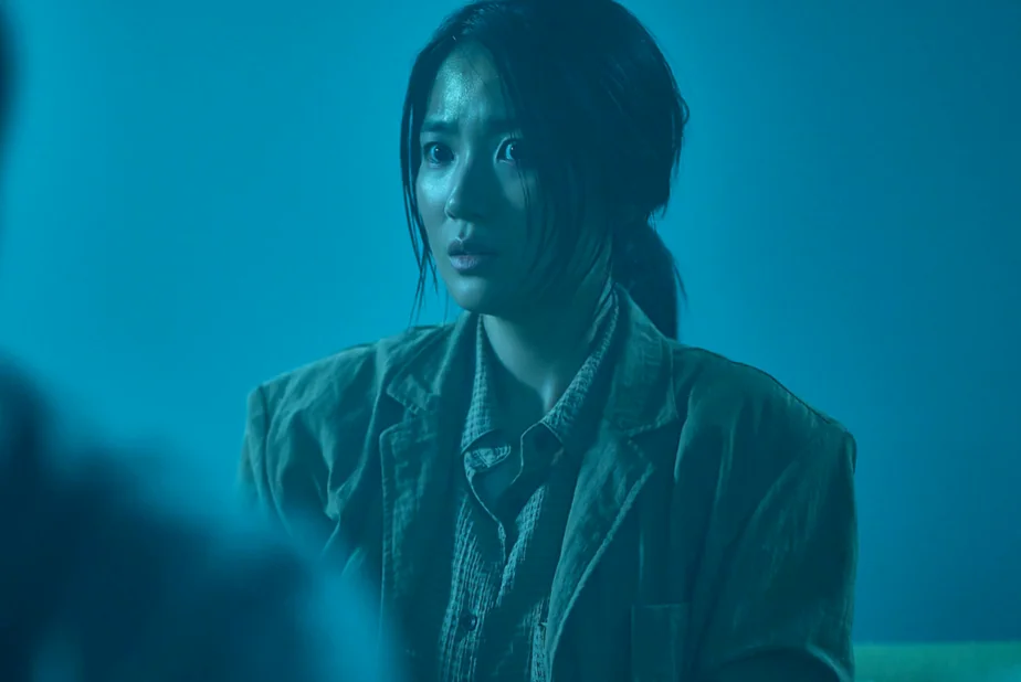 冷たい青い照明の下でパニックに陥った表情を見せる女性キャラクターのクローズアップ - 韓国を震撼させる映画『サルモクチ』の世界。忠清南道・礼山への聖地巡礼ガイド