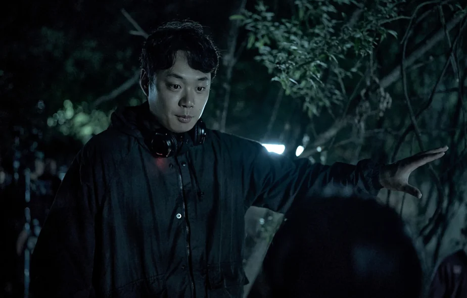 夜の森で目に見えない何かを指差す暗い服を着た男性 - 韓国を震撼させる映画『サルモクチ』の世界。忠清南道・礼山への聖地巡礼ガイド