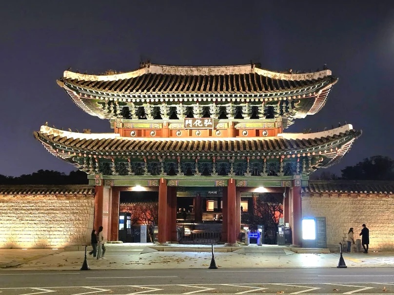 温かいスポットライトがその高さを強調する、壮大な王宮の正門の夜景 - 2026年ソウル、夜の王宮を彩る光の祭典。昌慶宮'水光蓮花'完全ガイド