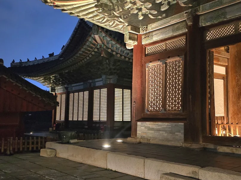 夜の照明に照らされた、王宮の軒下の鮮やかな丹青（ダンチョン）模様の細部 - 2026年ソウル、夜の王宮を彩る光の祭典。昌慶宮'水光蓮花'完全ガイド