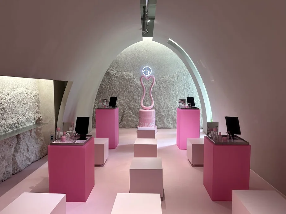 alt: アーチ型の天井の下、ピンクの台座が並ぶシンメトリーなメインホール - 江南の美の殿堂｜Cclime Beauty Museumで体験する究極の小顔デザイン