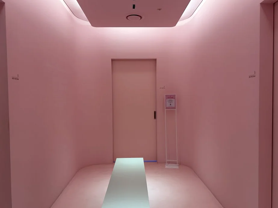alt: 柔らかなピンクの光に包まれた静かな待機スペース - 江南の美の殿堂｜Cclime Beauty Museumで体験する究極の小顔デザイン