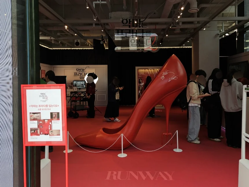 The grand interior view from the entrance, dominated by a massive red high-heel sculpture and a plush red carpet, setting an immersive atmosphere. - The Devil Wears Prada 2: An Exclusive Pop-Up Showroom Experience in Seoul's Seongsu District