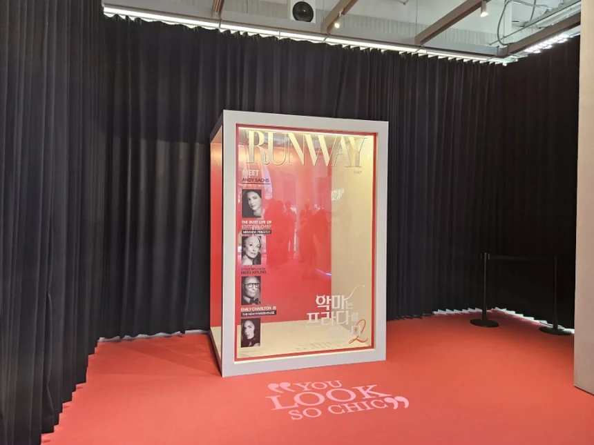 A display case showcasing film-themed costumes and accessories, with the phrase 'IF YOU LOOK SO CHIC' elegantly inscribed on the floor. - The Devil Wears Prada 2: An Exclusive Pop-Up Showroom Experience in Seoul's Seongsu District