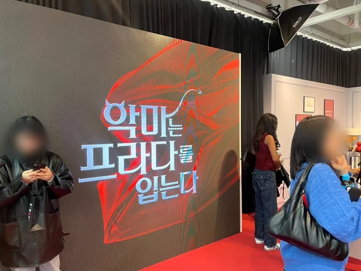 A large digital display inside the showroom, prominently featuring 'The Devil Wears Prada' logo as a central branding element. - The Devil Wears Prada 2: An Exclusive Pop-Up Showroom Experience in Seoul's Seongsu District