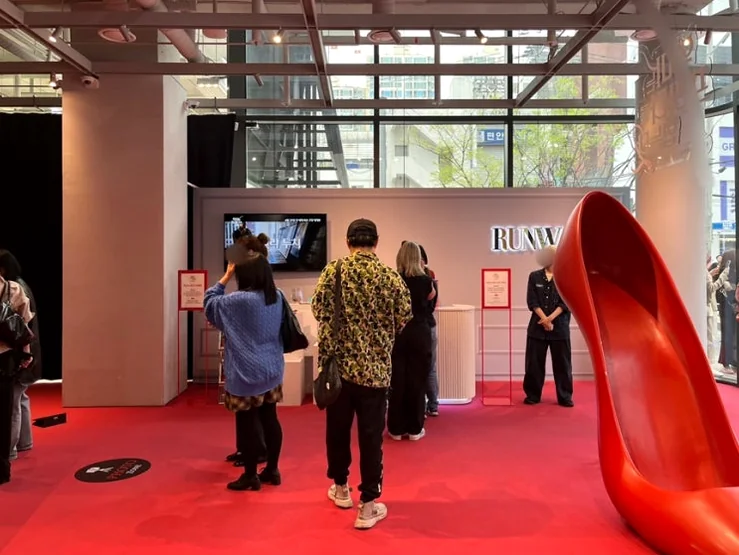 An expansive interior view of the showroom from another angle, capturing visitors interacting with the space and the towering high-heel sculpture. - The Devil Wears Prada 2: An Exclusive Pop-Up Showroom Experience in Seoul's Seongsu District