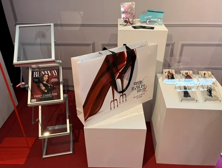 A neatly arranged merchandise display stand, featuring a curated selection of goods and souvenirs on clean white platforms, reflecting a sophisticated flat-lay aesthetic. - The Devil Wears Prada 2: An Exclusive Pop-Up Showroom Experience in Seoul's Seongsu District