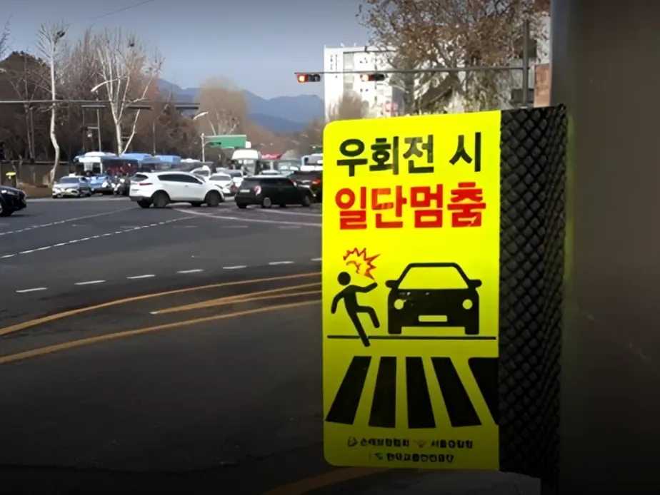 A cinematic close-up of a glowing red traffic signal at twilight reflecting off the sleek surfaces of waiting cars - Navigating the Pause: The Essential 2026 Guide to Korea’s Right-Turn Regulations