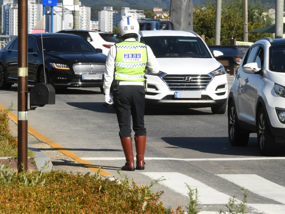 An aesthetic high-angle view of multiple zebra crossings creating a rhythmic geometric pattern as people traverse the street - Navigating the Pause: The Essential 2026 Guide to Korea’s Right-Turn Regulations