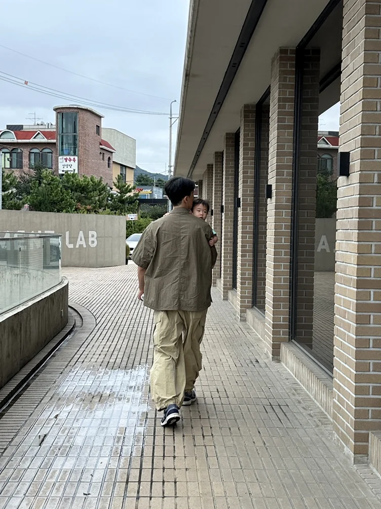 alt:フラッグシップストアの建築的な外観を歩く訪問者の後ろ姿 - ソウル近郊の美学、ムーブメントラボ義王で体験する究極のインテリア・キュレーション