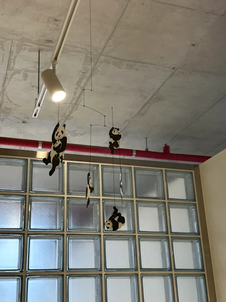 alt:ガラスブロックの窓がある工業的な天井から吊るされた、芸術的なパンダのモビール - ソウル近郊の美学、ムーブメントラボ義王で体験する究極のインテリア・キュレーション
