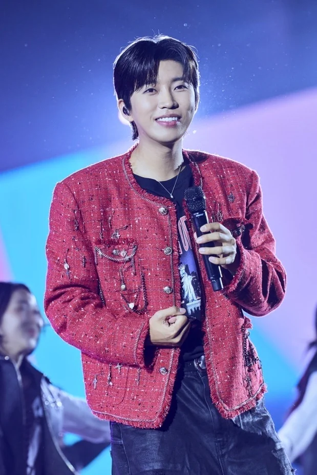 Lim Young-woong performing on stage, wearing a striking red tweed jacket over a dark shirt, with bright stage lights in the background - Lim Young-woong Shatters Streaming Records: The Rise of Korea's Unrivaled Solo Icon