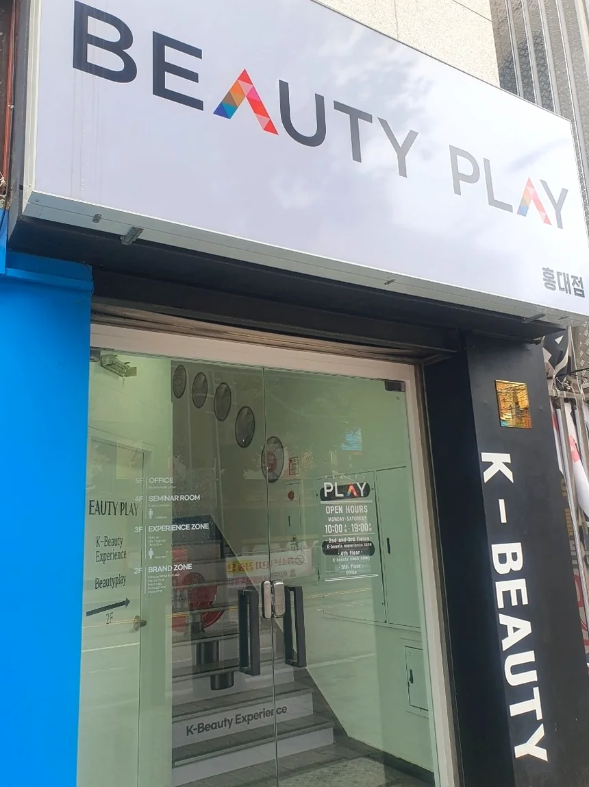 A vertical branding sign at the entrance emphasizing the global identity of K-Beauty within the building. - Unlocking the K-Beauty Ethos: A Discerning Guide to Beauty Play Hongdae