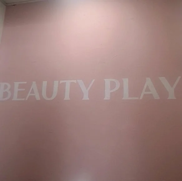 A sophisticated pink feature wall adorned with the Beauty Play logo, reflecting the premium aesthetic of the interior design. - Unlocking the K-Beauty Ethos: A Discerning Guide to Beauty Play Hongdae