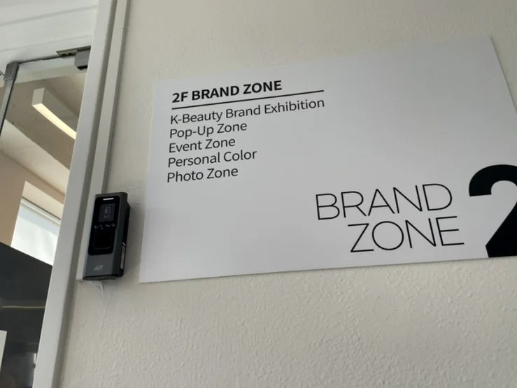 A sleek directional wall sign pointing toward the 2F Brand Zone, showcasing the clean, modern typography of the facility. - Unlocking the K-Beauty Ethos: A Discerning Guide to Beauty Play Hongdae