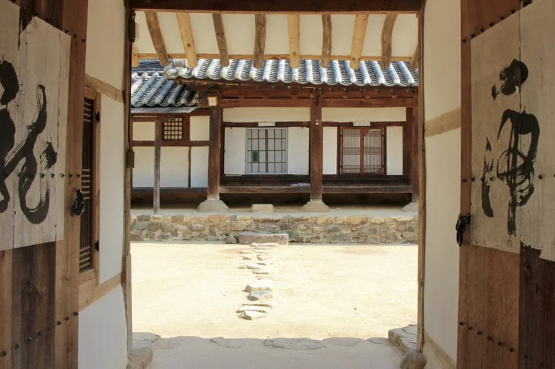 A perspective shot looking through an open traditional gate, revealing the inner courtyard and the structural beauty of the Hanok beyond. - A Sanctuary of Scholarly Grace: Exploring the Timeless Otgol Village in Daegu