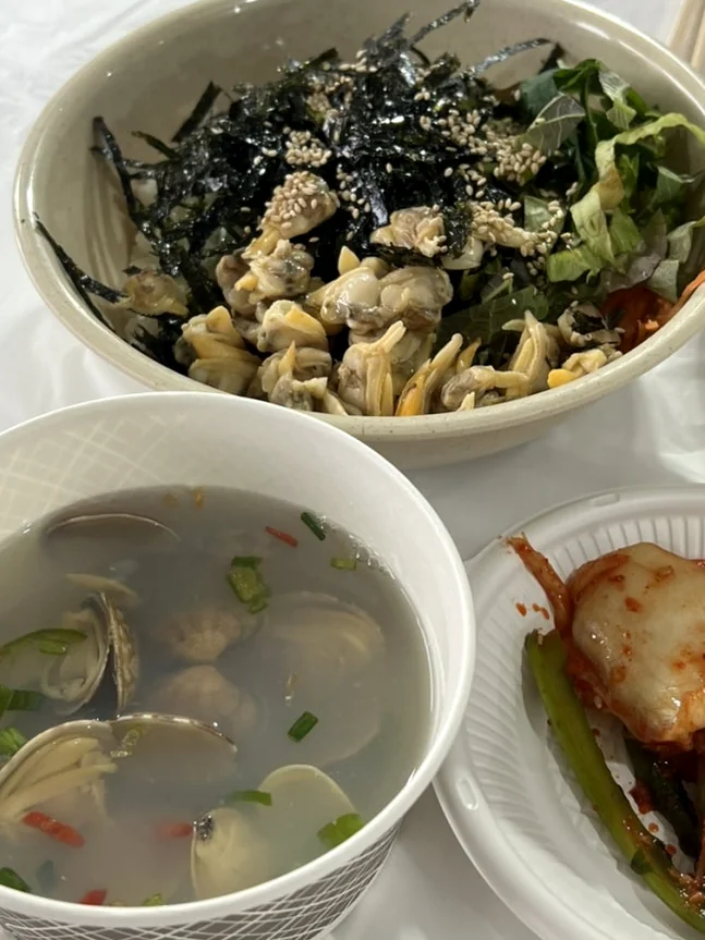 alt: 地元のアサリ料理（ビビンバとスープを含む）を鮮明に、よく照らされた料理写真。フェスティバルの主要食材の本格的な食感と新鮮さを強調しています。</div - 『K-Life Hack』厳選！高敞ハジョンアサリ五感体験フェスティバルで贅沢な韓国の自然を満喫する旅