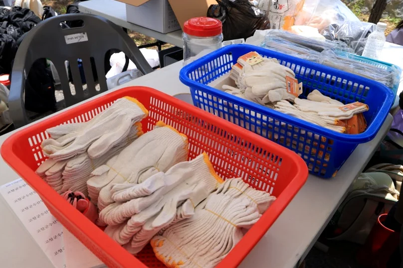 alt: 参加者用に用意された、白い綿手袋で満たされたカラフルなプラスチック製のバスケットの詳細なクローズアップショット。イベントの準備の具体的な様子を捉えています。 - 『K-Life Hack』厳選！高敞ハジョンアサリ五感体験フェスティバルで贅沢な韓国の自然を満喫する旅
