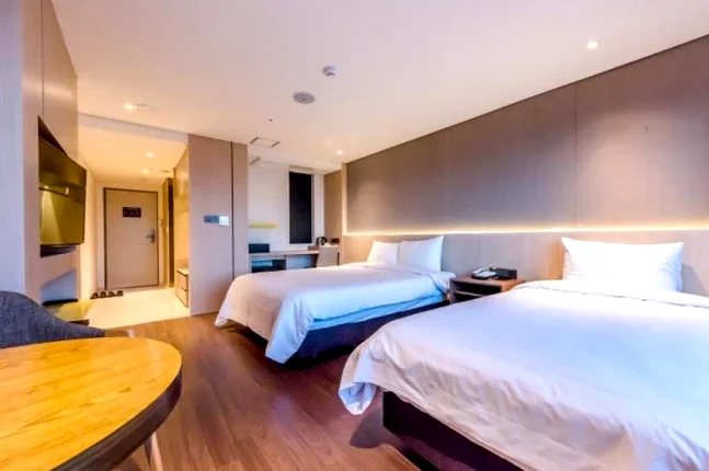 A spacious and meticulously clean twin guest room featuring modern minimalist decor and natural lighting - A Curated Stay in Seogwipo: The Unrivaled Value of The First 70 Hotel