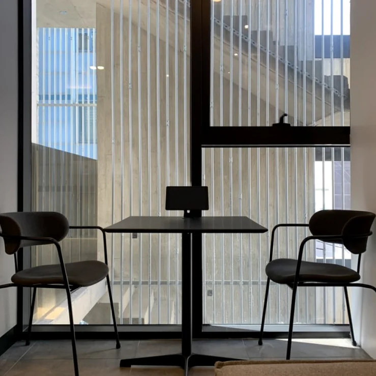 Minimalist seating area with a sleek table and chairs positioned against a large window with vertical blinds for a clean spatial aesthetic - Architectural Volume: The Discerning Expats Guide to The Objet Cheongdam