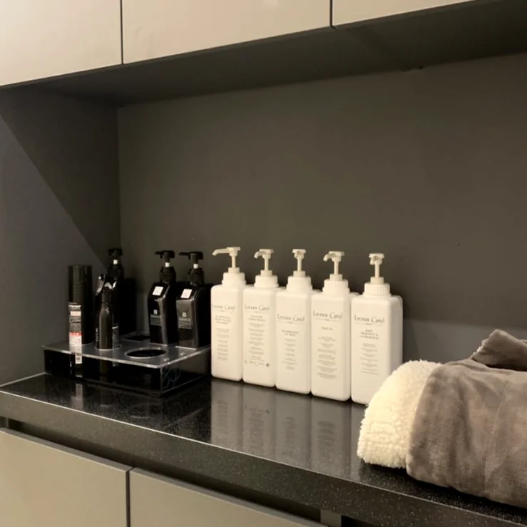 Uniformly arranged professional hair care products on a polished black counter highlighting the salon's curated selection - Architectural Volume: The Discerning Expats Guide to The Objet Cheongdam