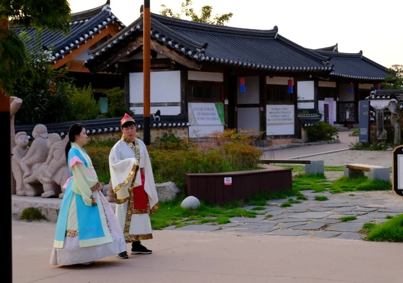 A couple in elegant Hanbok strolling through a historic Korean garden. - Gyeongju Hanbok Experience: Unveiling Silla's Elegance at Kkotgil Hanbok