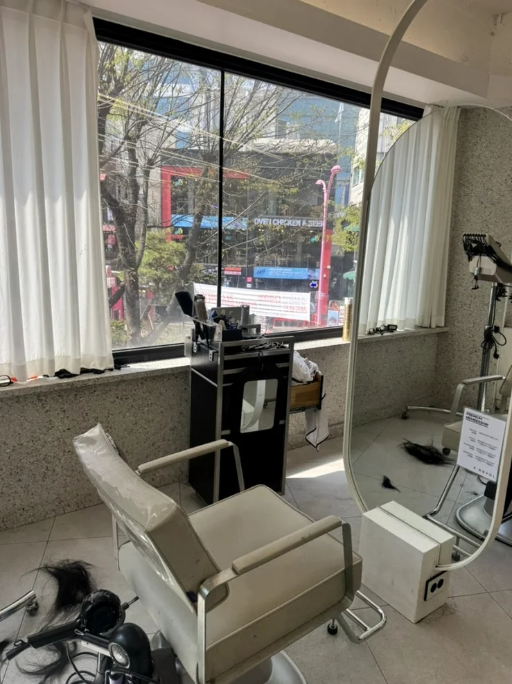 A serene view of a styling station situated by a large window overlooking lush city greenery - Beyond the Neon: The Precision of K-Beauty Mastery at Argyol Hongdae