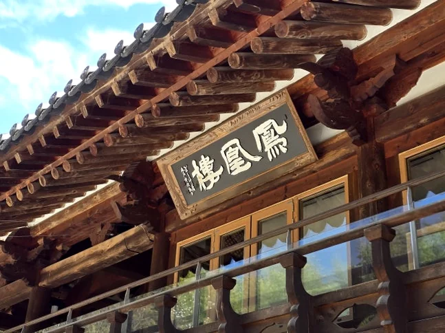 A wide panoramic view of the traditional Hanok building, Bonghwang-nu, situated at the entrance of Juknokwon under a clear blue sky. - The Vertical Elegance of 죽녹원: A 2026 Masterclass in Bamboo Minimalist Living