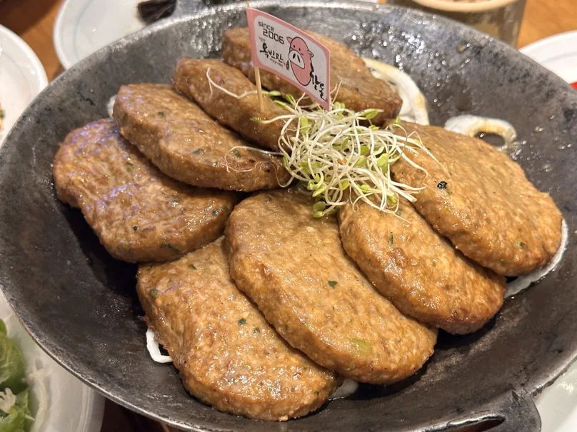 A close-up of authentic Damyang Tteok-galbi (grilled short rib patties) served in a traditional iron plate, representing local culinary excellence. - The Vertical Elegance of 죽녹원: A 2026 Masterclass in Bamboo Minimalist Living