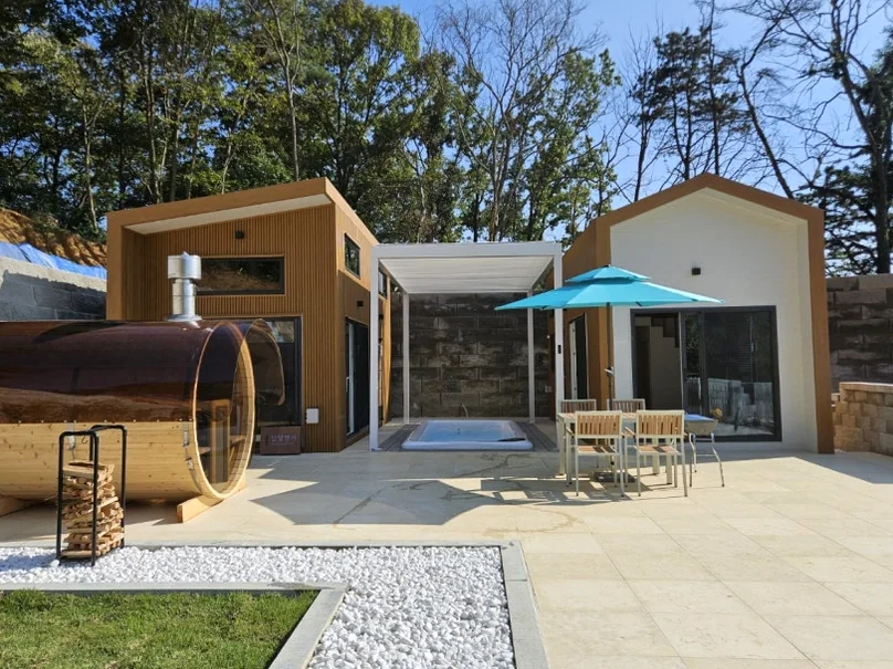 A daytime shot of the contemporary accommodation featuring a unique barrel-shaped outdoor sauna and a private pool. - The Vertical Elegance of 죽녹원: A 2026 Masterclass in Bamboo Minimalist Living