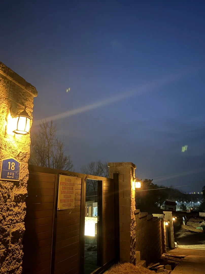 The stone pillar and lamp at the entrance of the private villa under a deep blue twilight sky. - The Vertical Elegance of 죽녹원: A 2026 Masterclass in Bamboo Minimalist Living