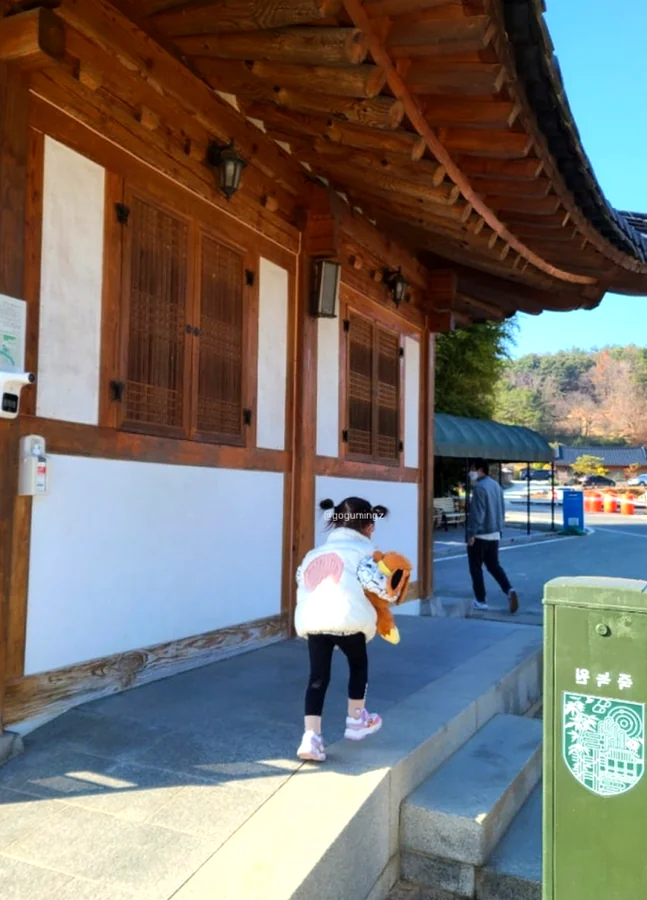 A child in a white jacket entering a traditional Hanok building, showing the scale and detail of the architecture. - The Vertical Elegance of 죽녹원: A 2026 Masterclass in Bamboo Minimalist Living