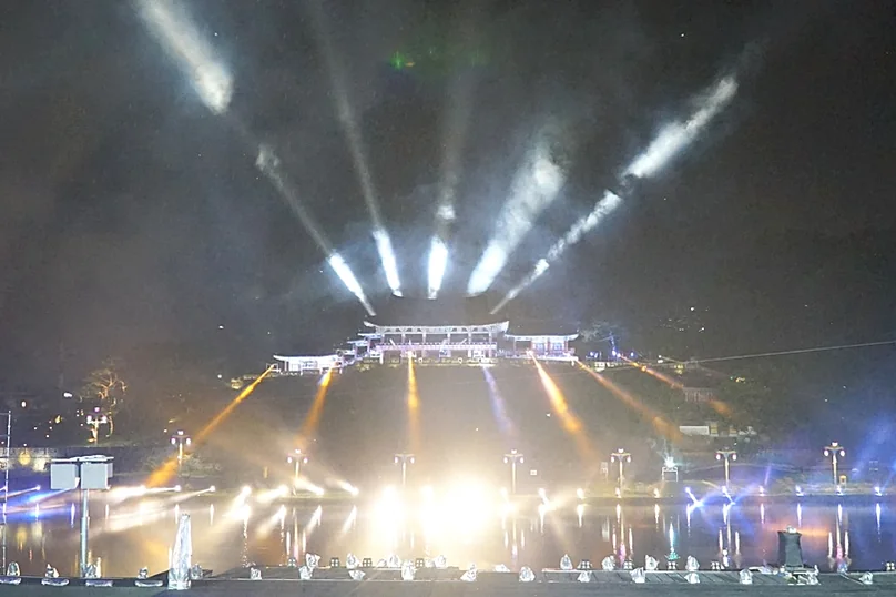 A wide shot of the festival stage at night, featuring a complex lighting setup with spotlights reflecting on the water, creating a dramatic atmosphere. - The 68th Miryang Arirang Festival: A Timeless Korean Cultural Spectacle