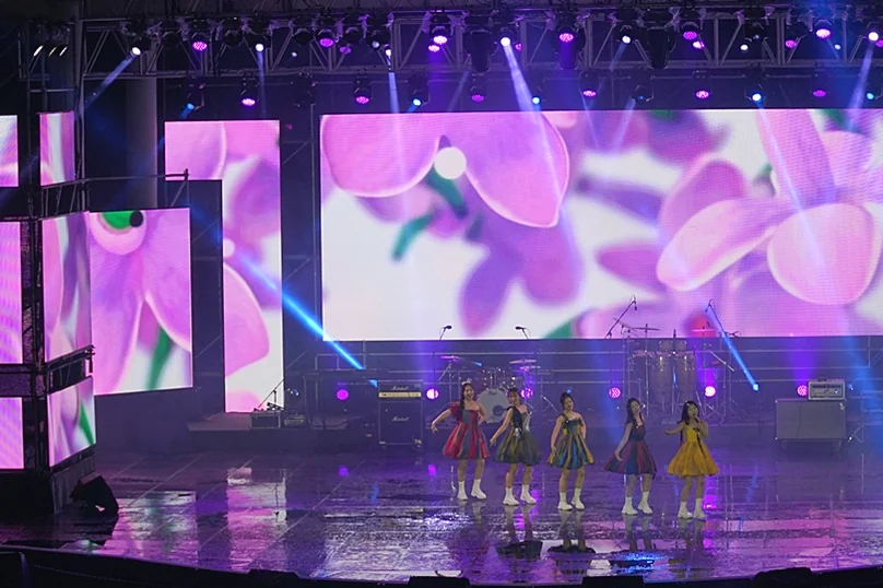 A K-Pop idol group performing on a large stage, flanked by vibrant purple LED screens displaying floral patterns. - The 68th Miryang Arirang Festival: A Timeless Korean Cultural Spectacle