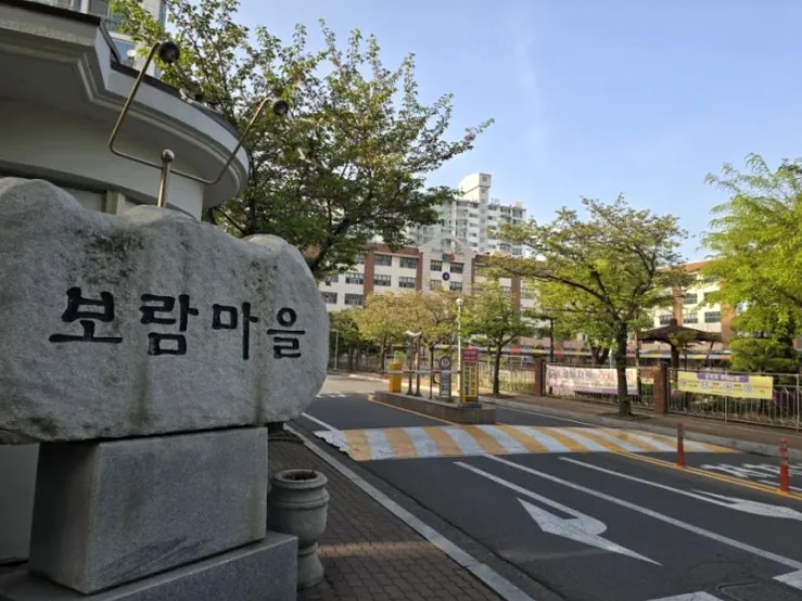 alt: 物語の物理的な舞台を象徴する「ポラム村」の石碑が写ったロケーションショット - 呪術と権力の狂騒曲、韓国映画『神明』が暴く2026年の真実と聖地巡礼の記録