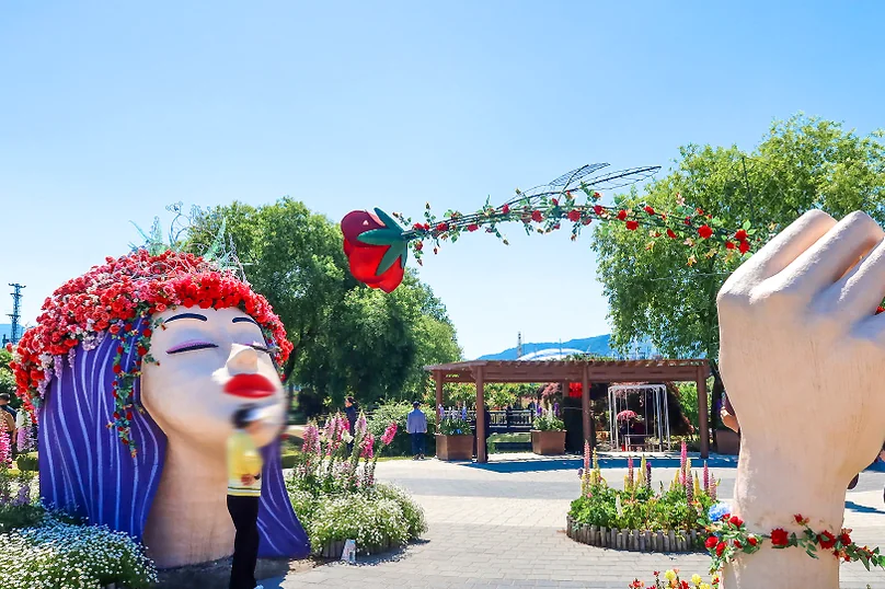 The rose sculptures from a wider perspective, showing the integration of art into the public park landscape. - The Floral Monarchy: Rediscovering Nostalgia at Gokseong Seomjingang Train Village