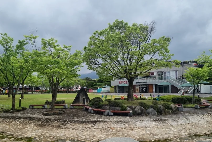 A quiet green space featuring mature trees and a traditional rest area, perfect for a slow-paced afternoon stroll. - The Floral Monarchy: Rediscovering Nostalgia at Gokseong Seomjingang Train Village