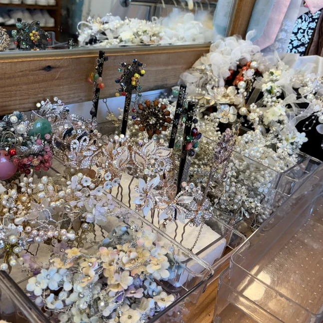 精巧な韓国の伝統的なかんざし（ピニョ）や花の髪飾りがディスプレイボックスに整理されている詳細な写真。 - 全州韓屋村で優雅な韓服体験：『貴族衣装室』で叶える特別な一日