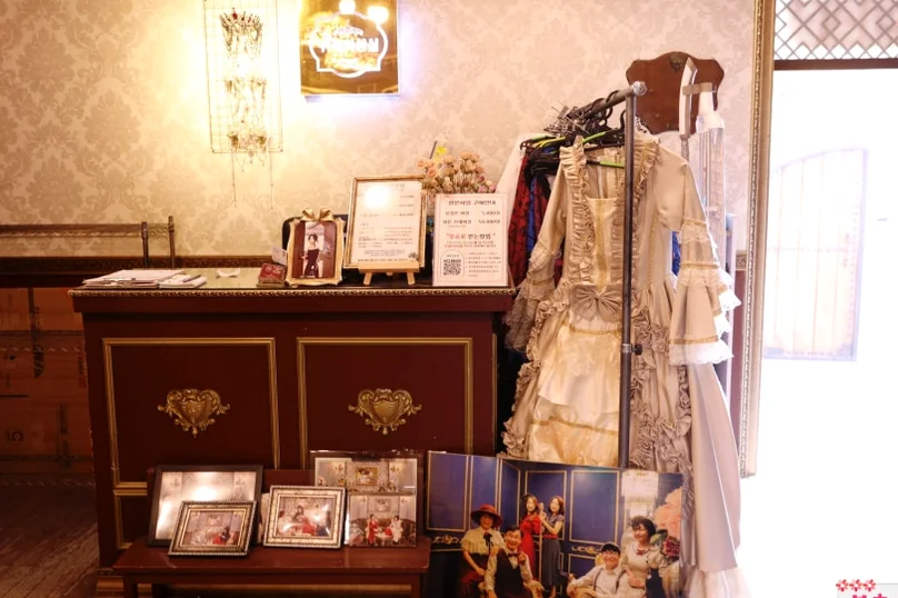 ブティックのカウンターエリア。時代衣装、サンプル写真アルバム、ヴィンテージの室内装飾が展示されています。 - 全州韓屋村で優雅な韓服体験：『貴族衣装室』で叶える特別な一日