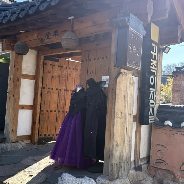 伝統的な韓国の門の前にヴィンテージ衣装を着用したマネキンが配置された店先入口。 - 全州韓屋村で優雅な韓服体験：『貴族衣装室』で叶える特別な一日