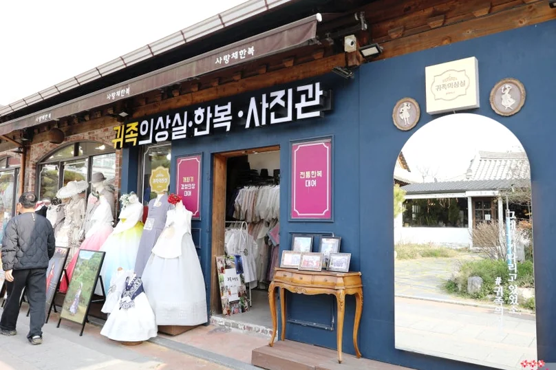 日中のブティック店先の外観写真。歩道にカラフルな衣装が多数レンタル用に展示されています。 - 全州韓屋村で優雅な韓服体験：『貴族衣装室』で叶える特別な一日