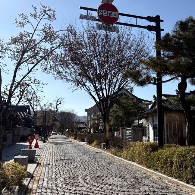 全州韓屋村の石畳の通りと伝統的な韓国の家々が広がる美しい景色。澄み切った青空の下。 - 全州韓屋村で優雅な韓服体験：『貴族衣装室』で叶える特別な一日